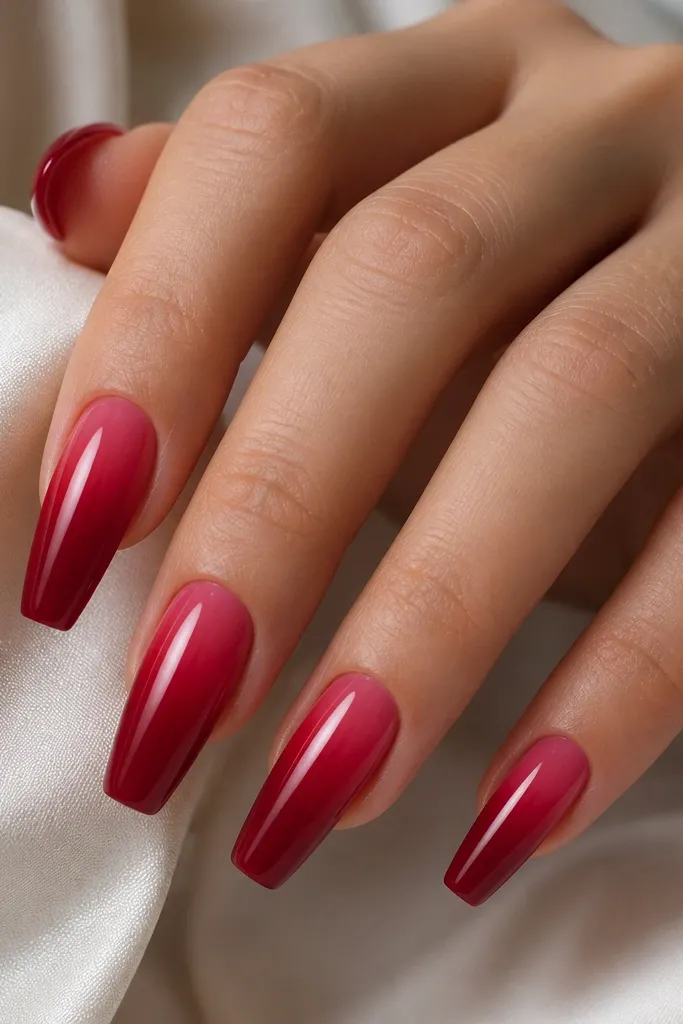 Medium coffin nails with a gradient from deeper cherry at the tips to a lighter, almost berry-red near the cuticle. The blend is smooth with a glossy finish.