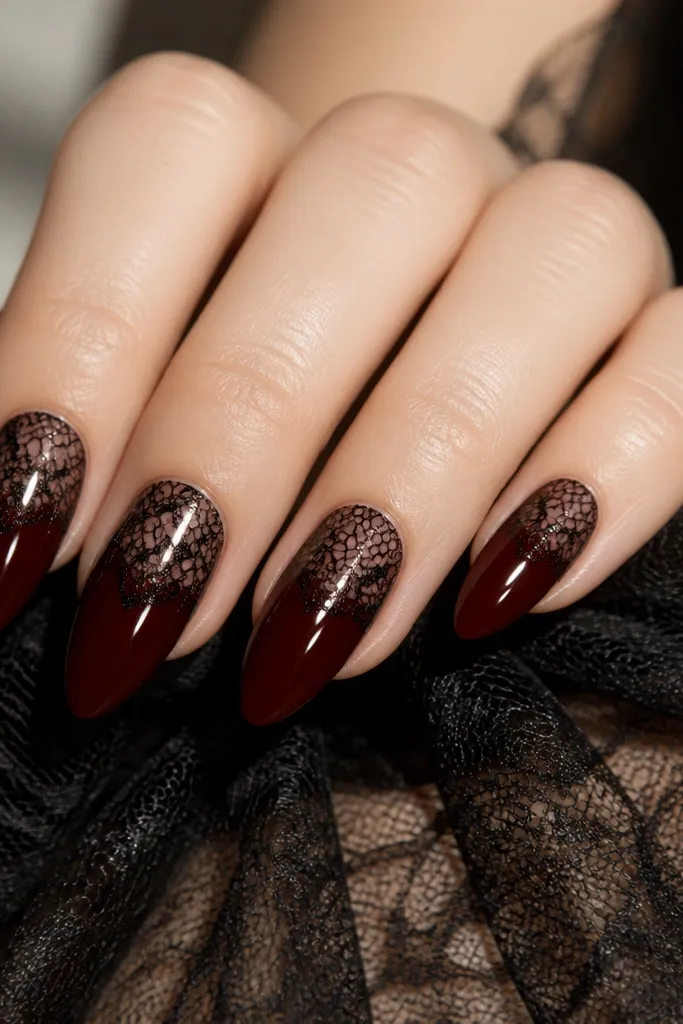 Dark cherry red nails with thin black lace patterns on the upper half, like a netted overlay, glossy finish, almond shape.