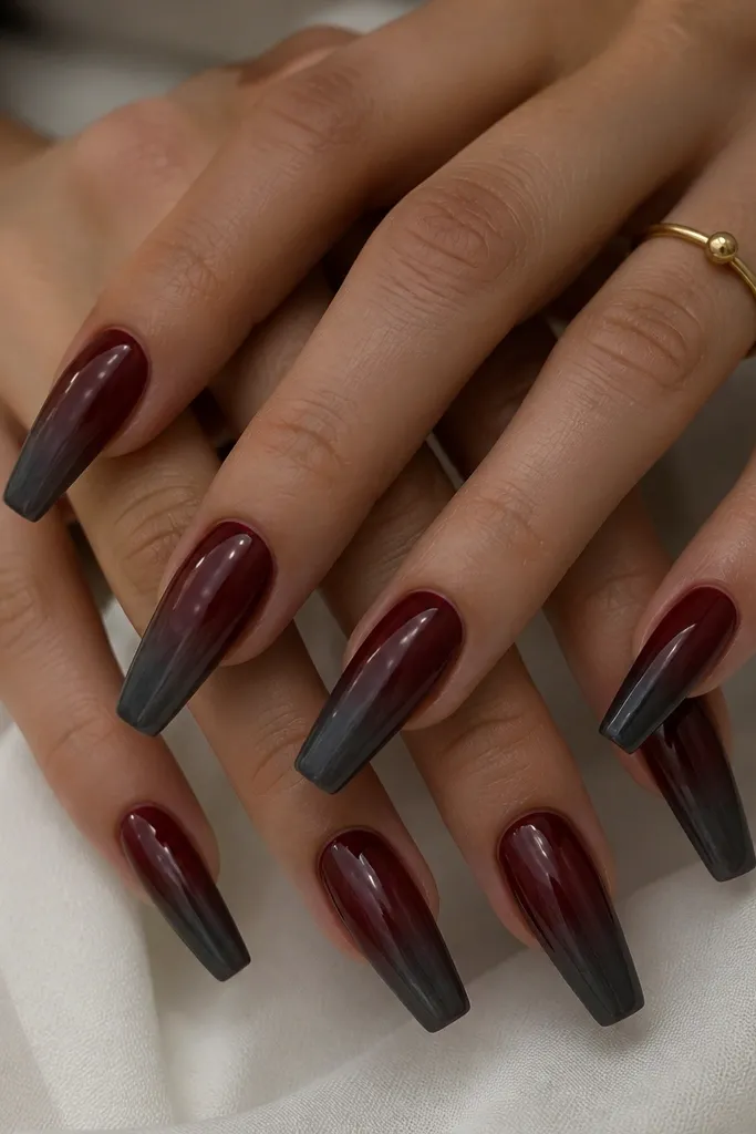 Long coffin nails painted dark cherry red with a smoky gray airbrush shadow at the tips. The gray fades upward into the cherry base, creating a blurred gradient like smoke.