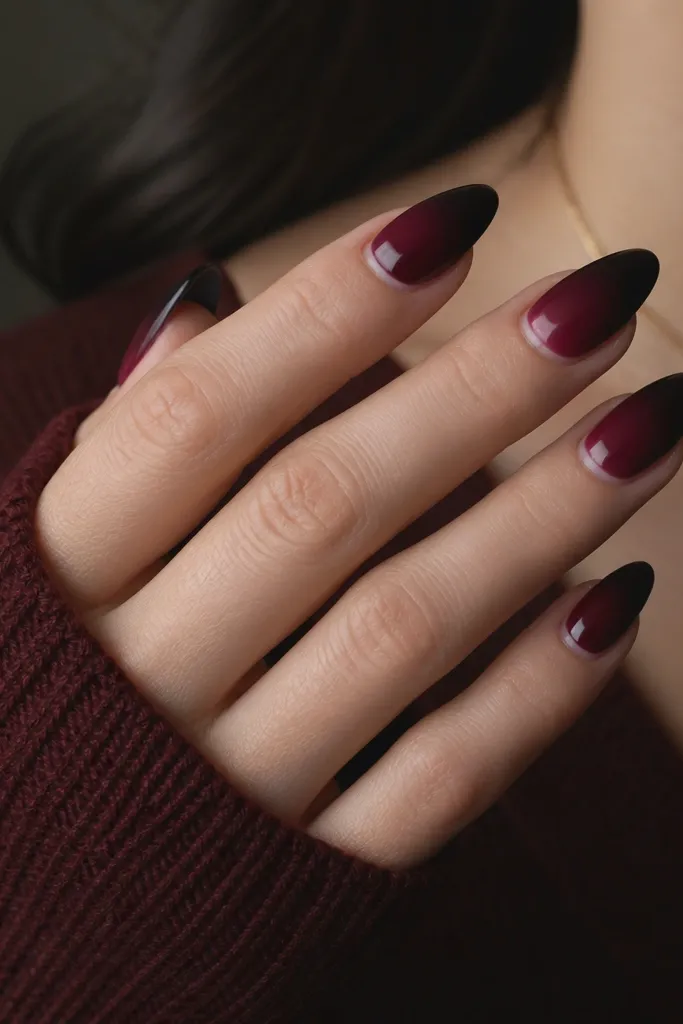 Almond nails where the color fades from dark cherry near the middle to a near-black burgundy tip at the free edge. The fade is smooth with a strong vampy gradient.