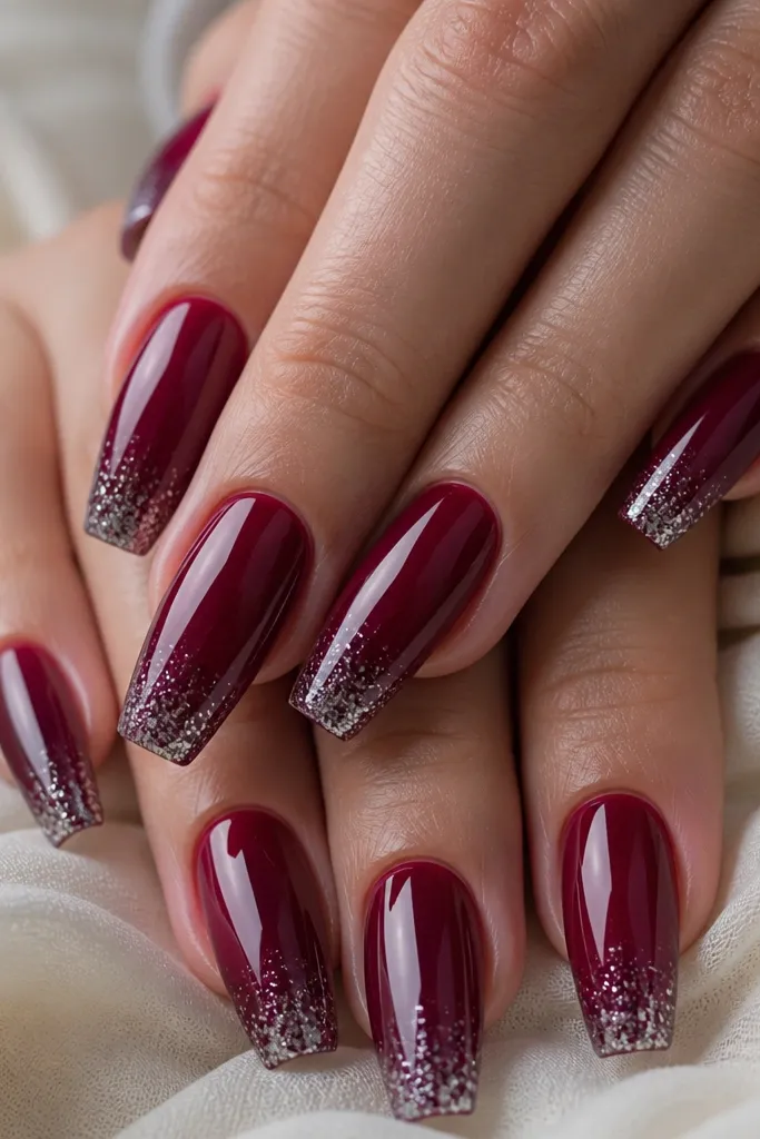 Coffin nails with a glossy dark cherry red base; the last third of each nail has fine silver micro-glitter concentrated at the tip.
