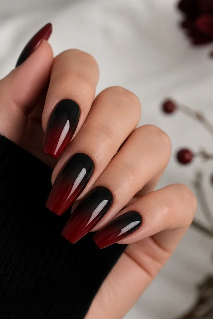 Coffin nails with a gradient from deep black near the cuticle fading into dark cherry red toward the tip, finished glossy.