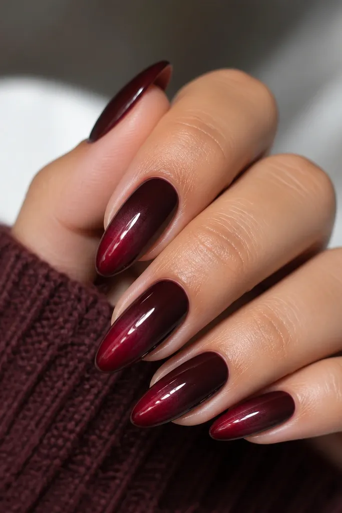 Almond nails with a dark cherry base. The French tip fades from dark wine at the very edge to a softer lighter cherry near the smile line, with a smooth glossy finish.