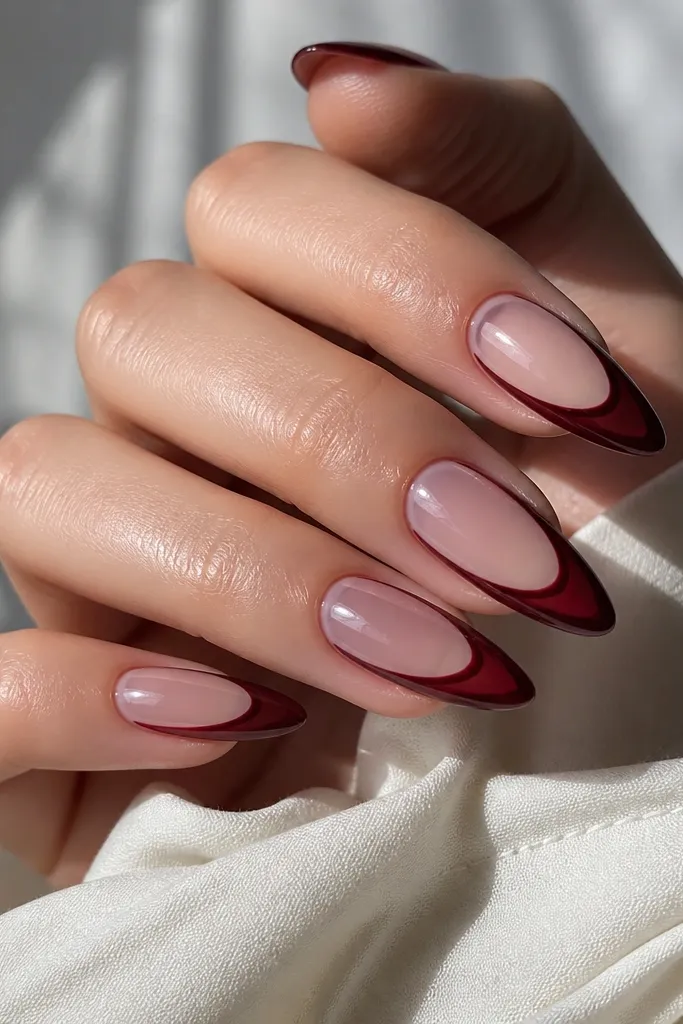 Almond nails with a clear jelly look base. The French tip is dark cherry only at the edge, creating a see-through center and a sharp cherry rim with glossy shine.