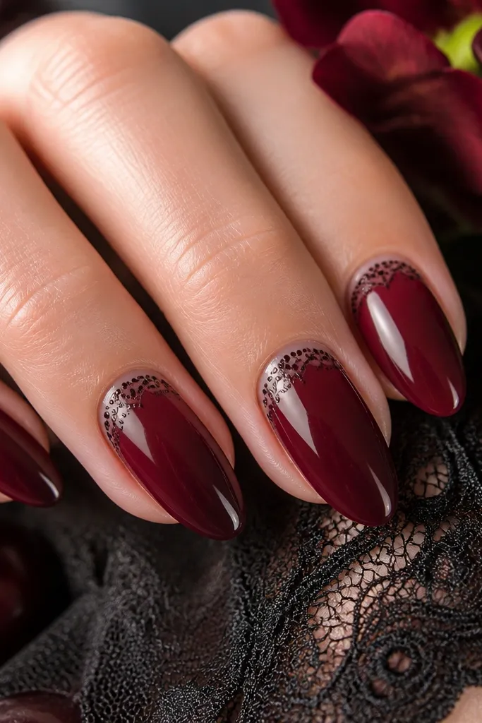 Almond nails in dark cherry red with tiny dot clusters near the cuticle forming a lace-like ring. The dots are silver or pale rose, spaced evenly and fading outward.