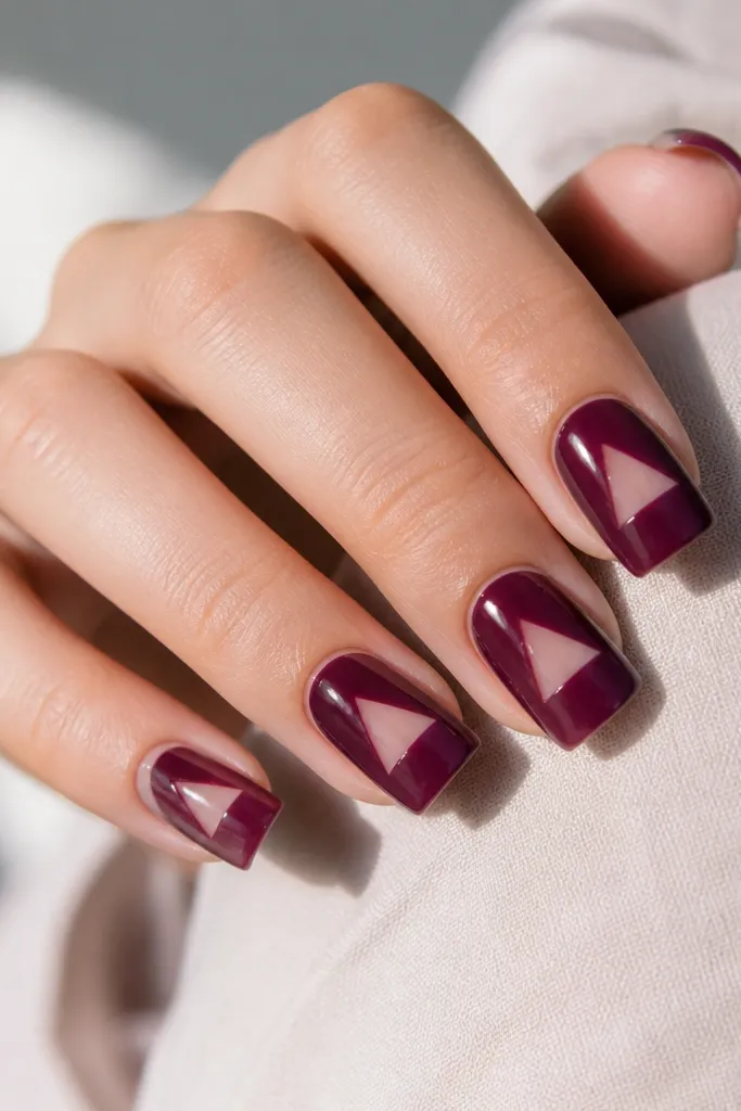 Square nails with a glossy clear nude base. A berry jam purple shape covers the top half, leaving a clear negative-space triangle near the center. The edges are sharp and the nails look glassy.