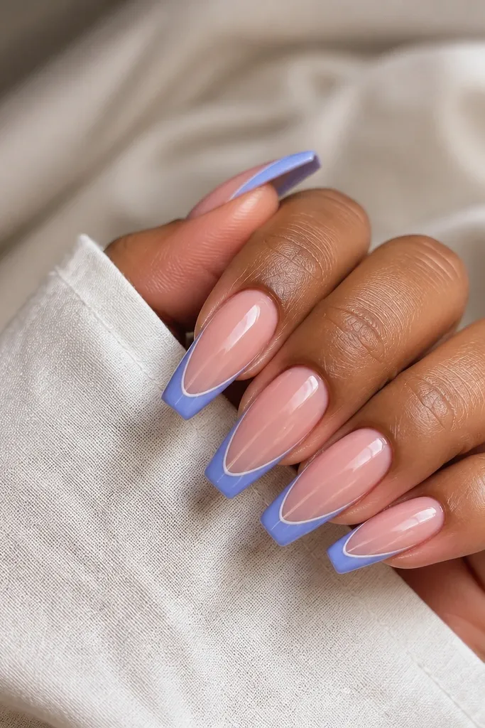 Long coffin nails with a translucent pink base. The French tip is periwinkle blue, and there's a thin white micro line running just inside the edge of the blue, parallel to the smile line. Glossy top coat.