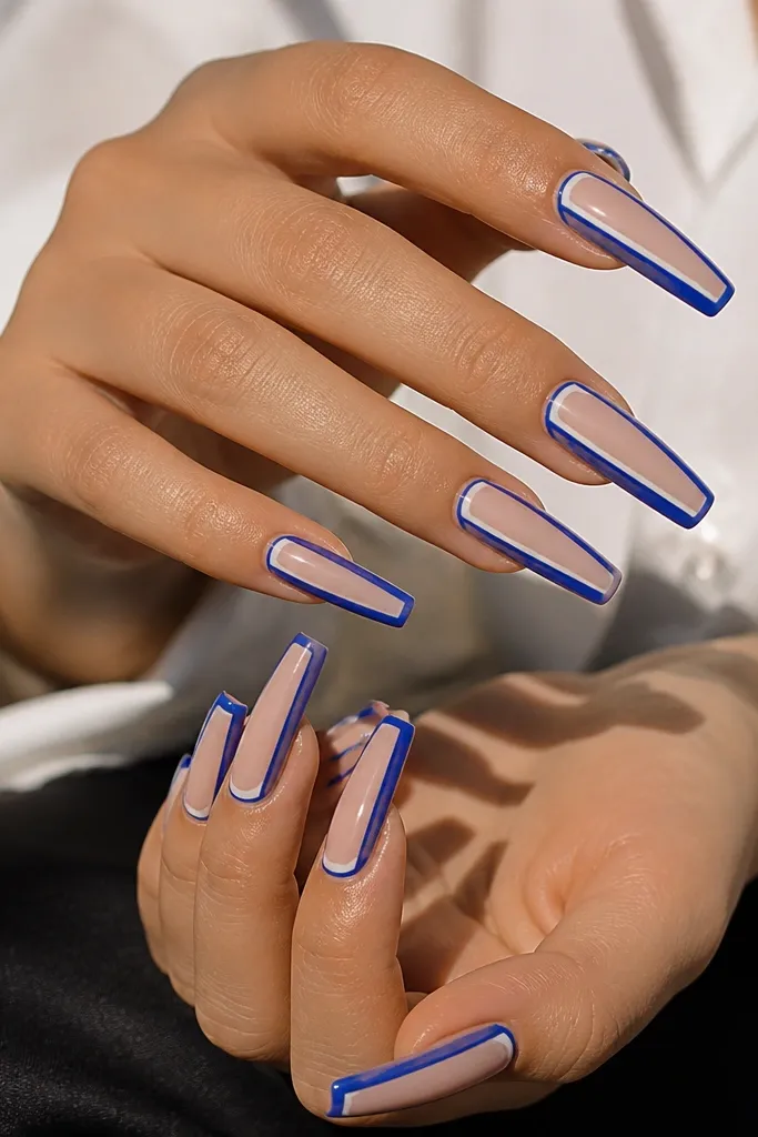 Long coffin nails with a nude base. There are two blue lines: a thicker royal blue outer French band and a thinner inner line closer to the center of the nail. Both lines are straight and symmetrical. Glossy finish.