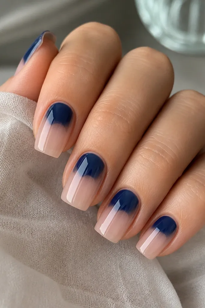 Square nails with clear or sheer nude bases. Only the top third has a deep blueberry jelly color, with the side edges left bare for negative space. The blueberry section has a glossy, slightly domed look.