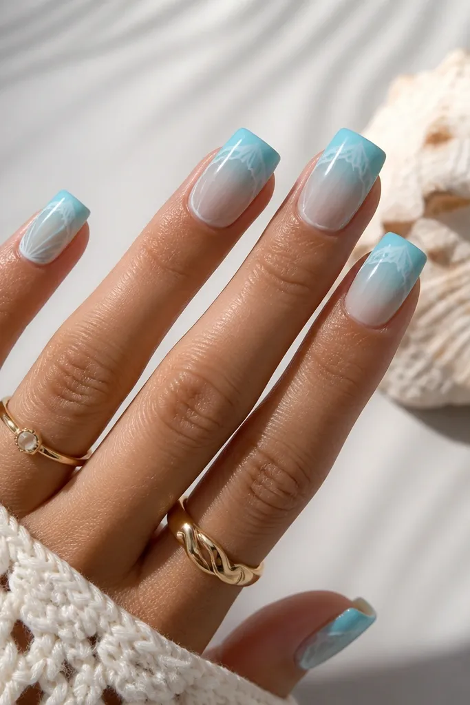 Square nails with aqua ombre from cuticle to tip in a smooth gradient. A thin white shell-like wave line sits across the top edge near the tip.