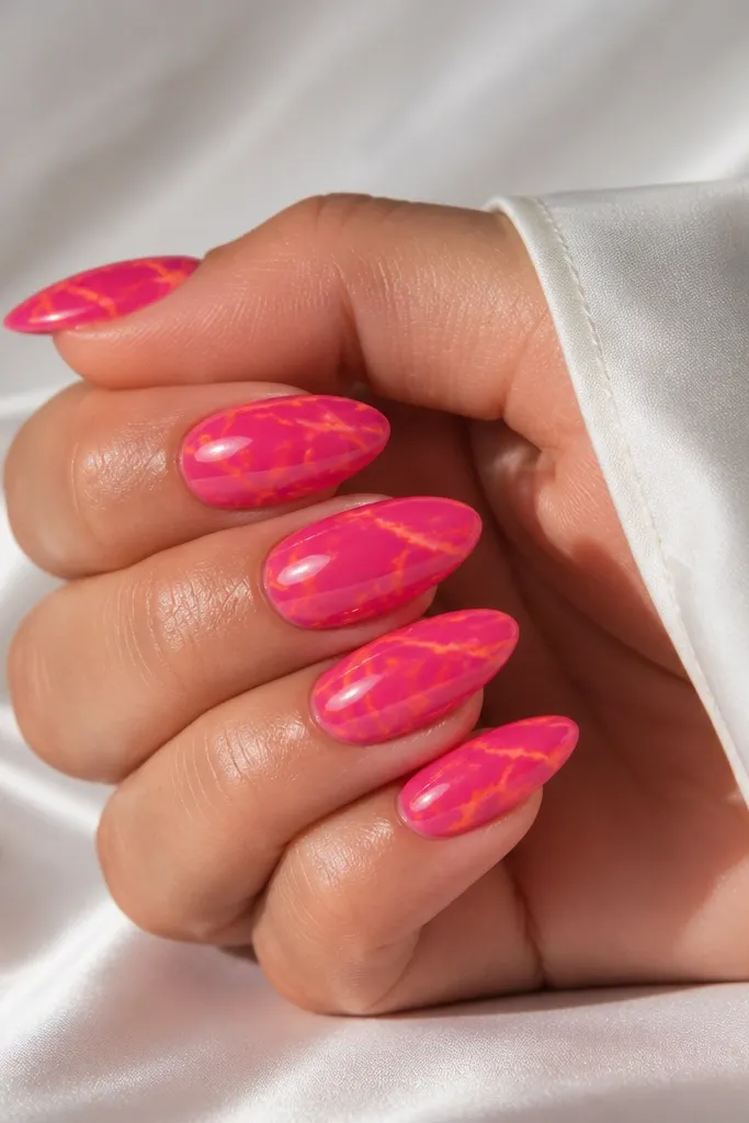 Almond nails with hot pink base and thin orange marble veining lines, glossy finish that looks like swirled stone.