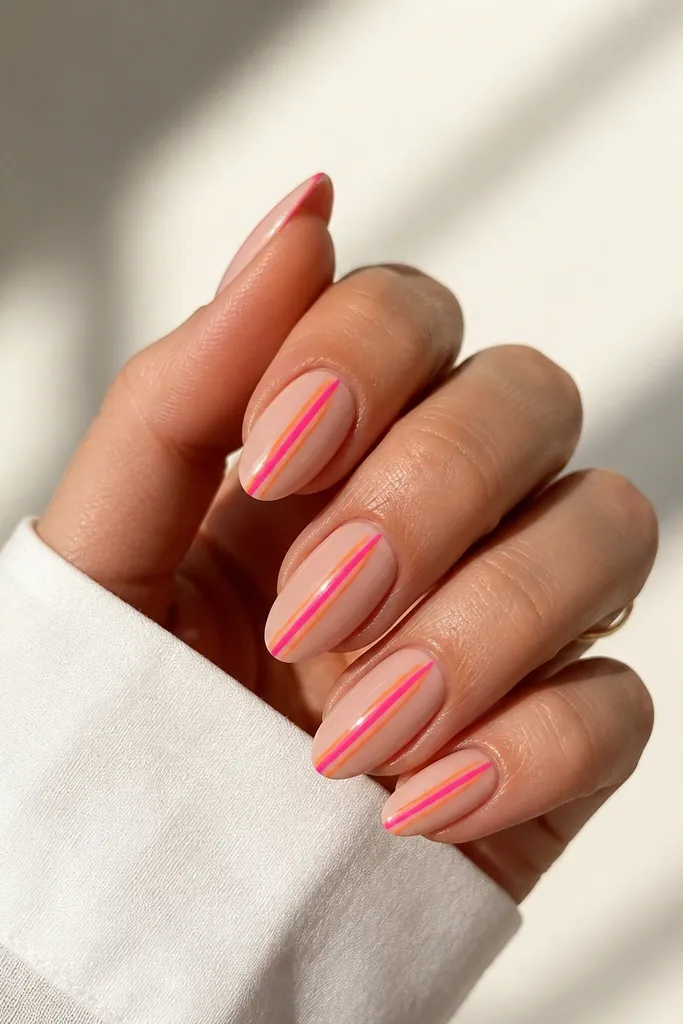 Medium almond nails with nude base and two parallel stripes running vertically: orange stripe and hot pink stripe, glossy finish.