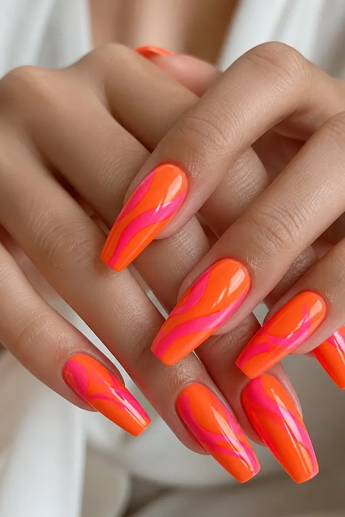 Coffin nails with bright orange base and a glossy hot pink swirl that loops across the nail, no other art.