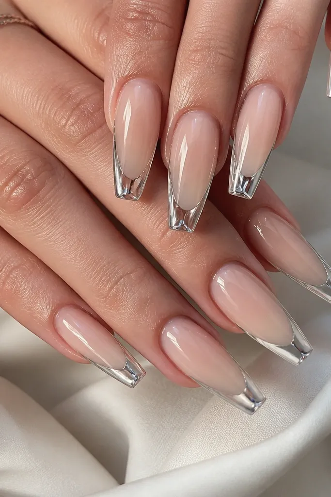 Coffin nails with a sheer nude base. The French tip is a clear jelly layer with embedded mirror silver chrome around the edge, creating a floating-glass effect. The silver looks like it's suspended under a glossy clear top.