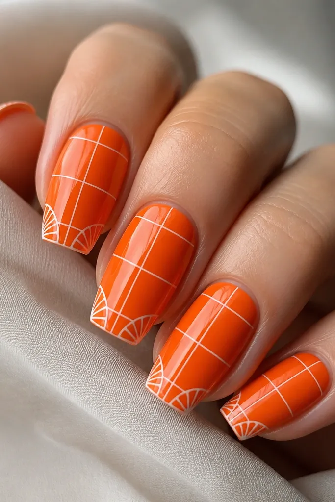 Long squoval nails painted bright orange. White lines form a subtle grid with curved shell-like corners near the tips. Glossy topcoat.