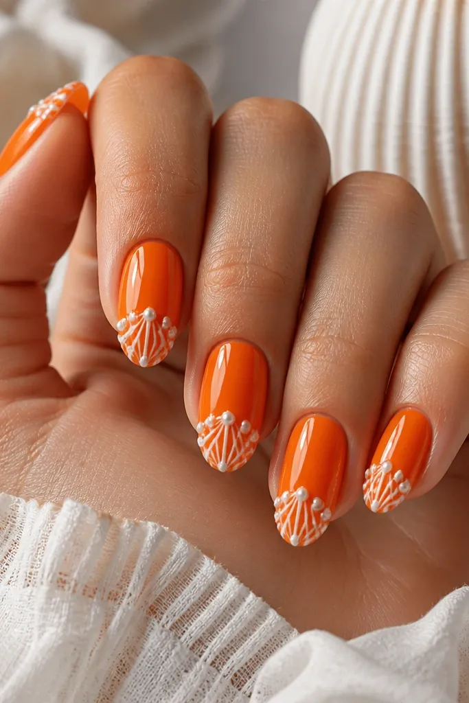 Medium almond nails in bright orange. White shell ridges appear on the tip, and tiny pearly dots sit at the ridge intersections. Glossy finish with raised dots that look like pearls.