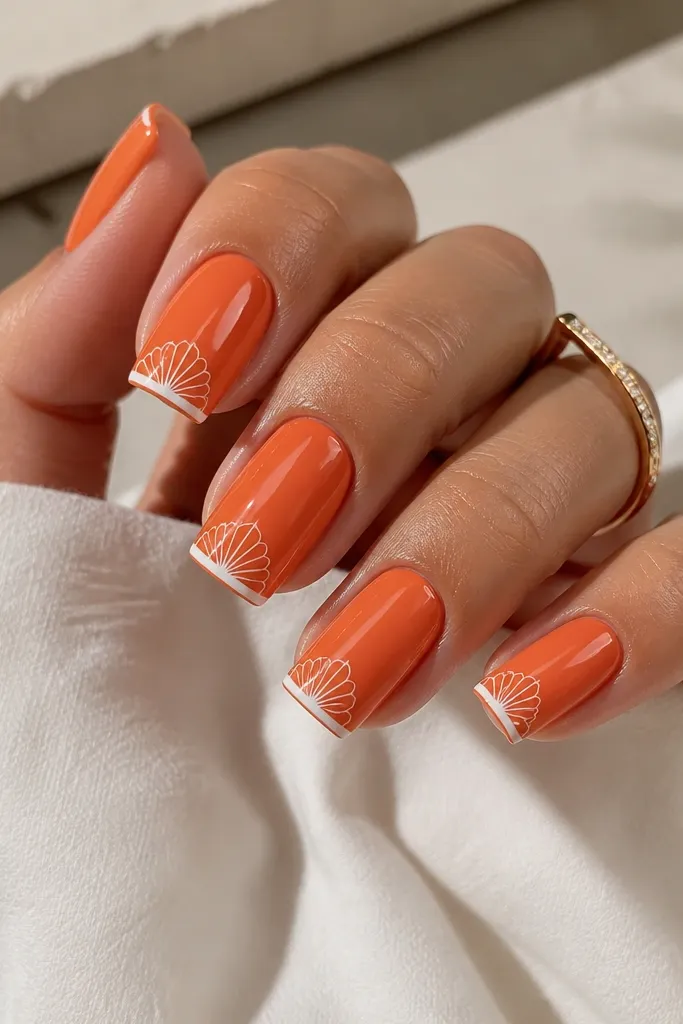 Square nails painted orange. The very edge of the tip is dipped in white polish like a thin border, and above it are subtle shell ridges in white. Glossy topcoat.