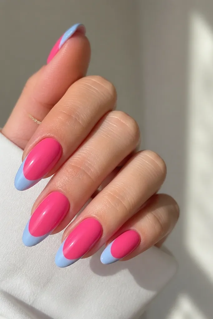 Long almond nails with a brighter hot pink base and pastel blue French tips. The tips are filled solid and glossy with a neat smile line.