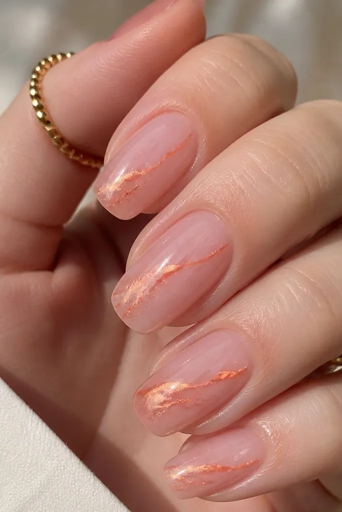 Translucent milky pink nails that look like soft jelly. Thin orange chrome veins run diagonally from near the sidewalls toward the tips, like metallic marble lines. The rest of the nail stays glossy and light.