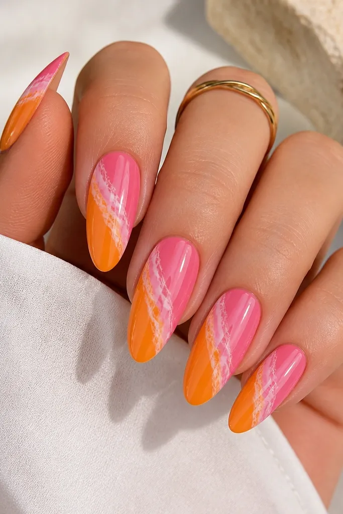 Long almond nails with a diagonal sweep across each nail. The lower-left area is glossy orange, and the upper-right area is glossy pink, with thin white marble veining running through the transition. The marble lines look hand-drawn, not speckled.