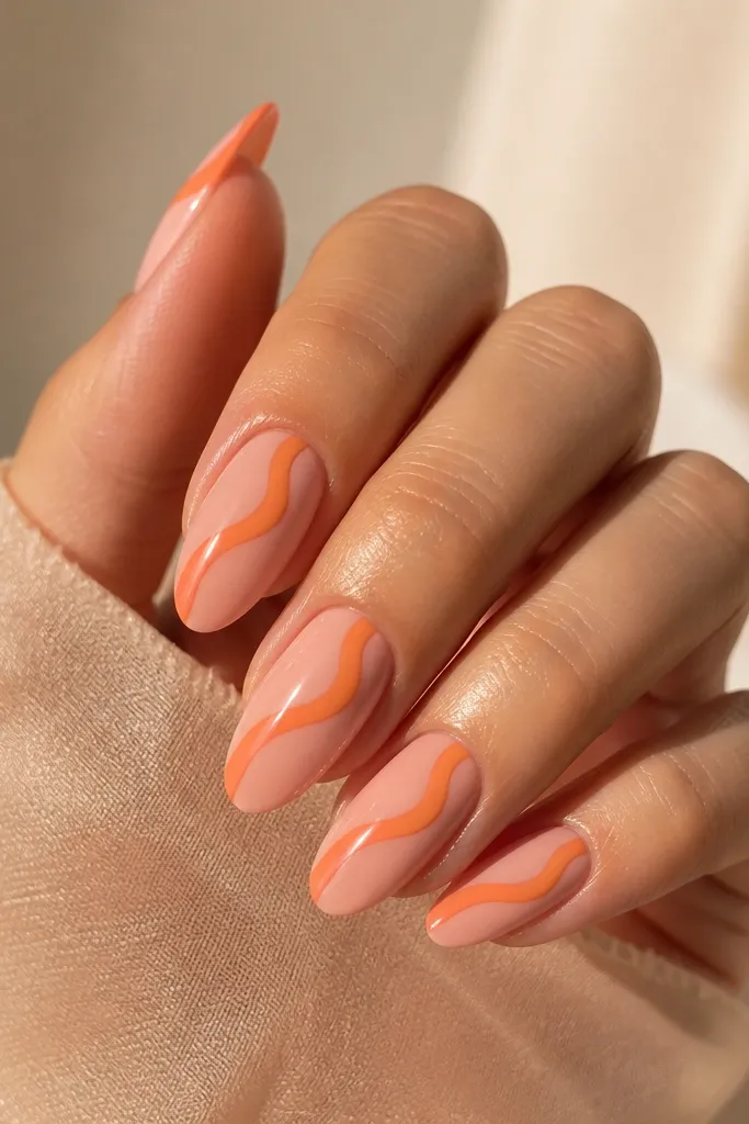 Long almond nails with a glossy pink base. Across the center runs a ribbon-like orange stripe with a slightly raised, smooth look, like a gel bead. The ribbon has soft edges and a gentle curve.