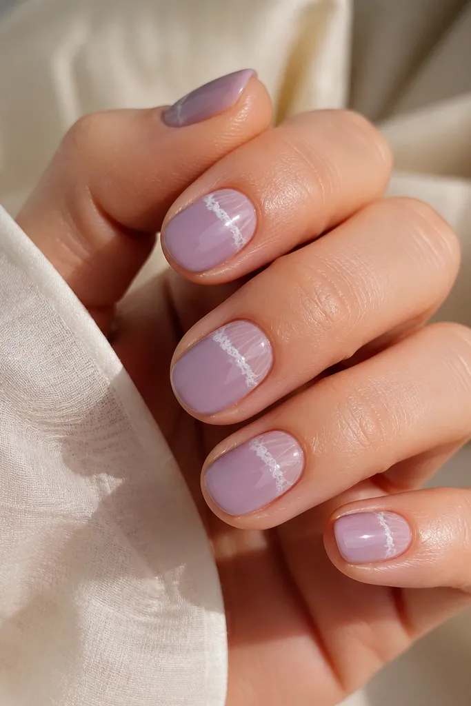 Short oval nails with a milky grape base. Each nail shows a half-shell ridge pattern in slightly lighter purple near the cuticle, and a crisp milky white foam line curving along the outer edge of the ridges. High-gloss finish, no glitter.