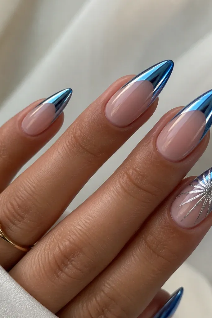 Long almond nails with blue chrome French tips; on one accent nail, a starburst of silver foil radiates from the center of the French area outward; other nails are plain chrome French; sharp mirror shine.