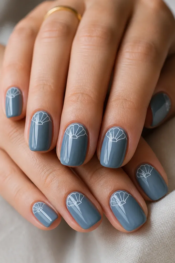 Nails are painted glossy blue-gray. On each nail there is a thin milk-white shell outline following a curved half-shell shape near the cuticle, with one inner arc line.