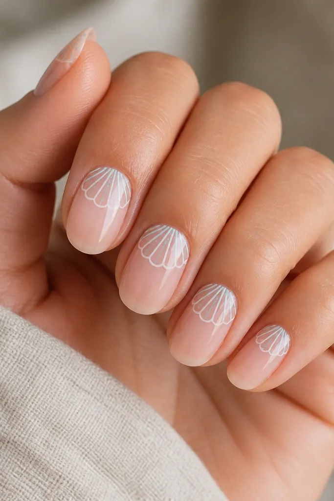 Nails have a light sheer base. There's a negative space shell outline made with pale teal and white lines, leaving most of the nail bare and glossy. The shell sits near the cuticle and curves toward the center.