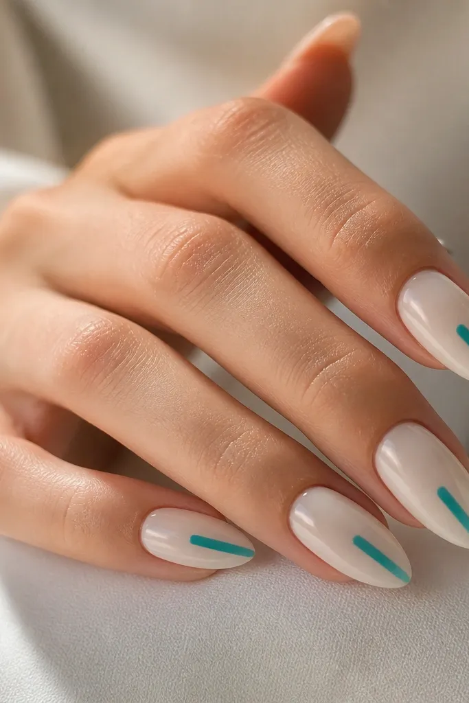 Almond nails in a milky sea-glass nude. On each nail there is a single vertical turquoise stripe running from just above the midline down toward the tip, with the rest of the nail solid and glossy.