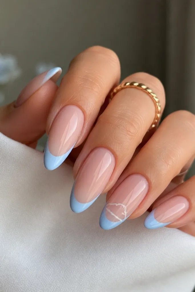 Long oval nails with sheer nude base. French tips are sky blue, glossy, crisp. One accent nail has fine white line art of a tiny cloud floating inside the tip area, with minimal strokes. Other nails are plain.