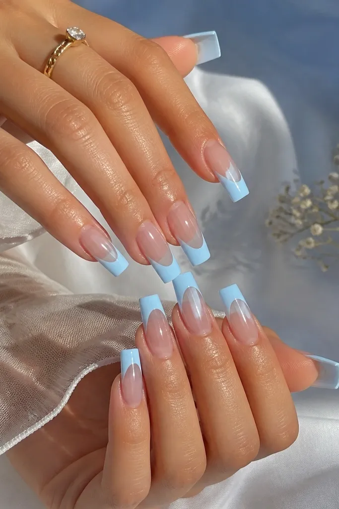 Long square nails with a clear base (no nude tint). French tips are icy sky blue, medium width, with crisp edges. The nails look glassy and see-through with a high gloss finish.