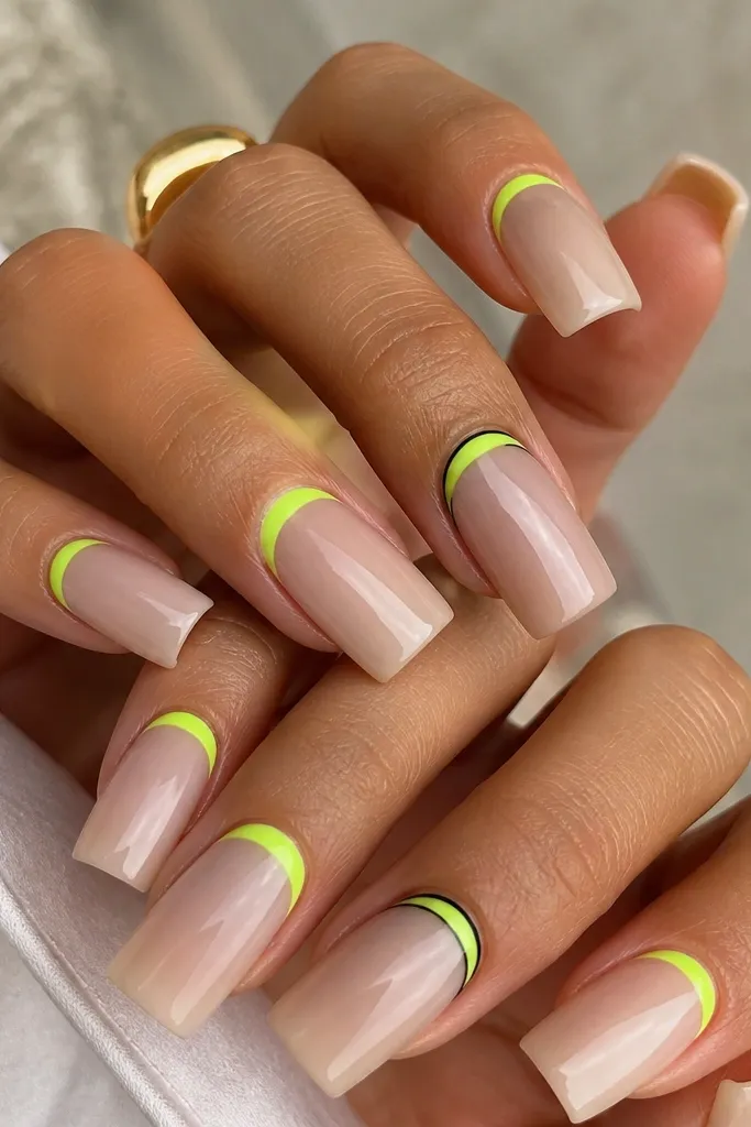 Long square nails with a clear or sheer nude base. A neon lime band sits right at the cuticle line, with a thin black outline around the band on two accent nails. Glossy finish.