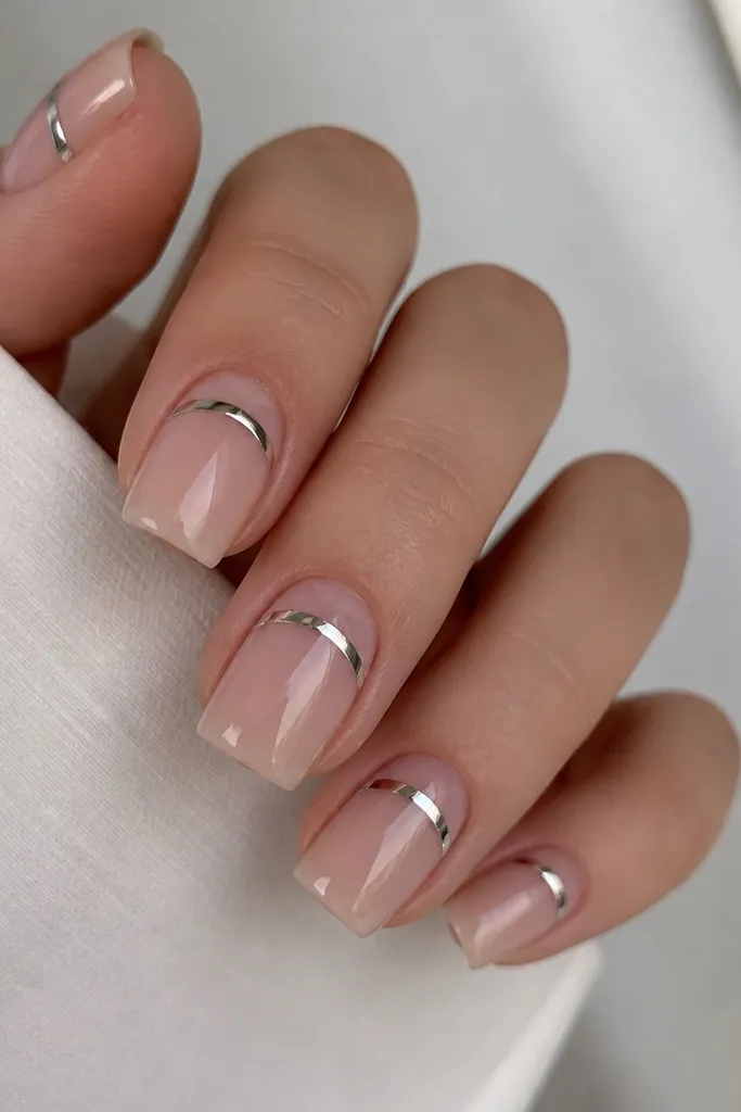 Square nails with a clear base. Instead of chrome at the tip, there's a chrome line across the upper part of the nail near the middle, shaped like a reverse French. The line is mirror silver.