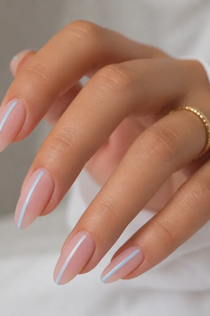 Glossy sheer pink almond nails with a single sky-blue vertical line running down the center-left of each nail; the rest is clear negative space and smooth nude base.