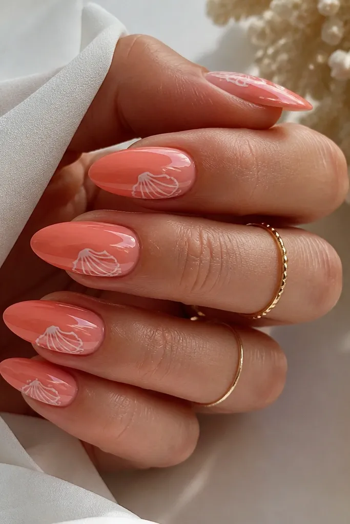 Almond nails with coral-pink base and a thin white seashell line art along one side of each nail; glossy.