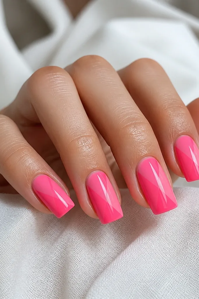 Square nails painted neon pink. Half of each nail has a glossy clear glaze layer creating a shiny wet look, divided by a straight diagonal line.