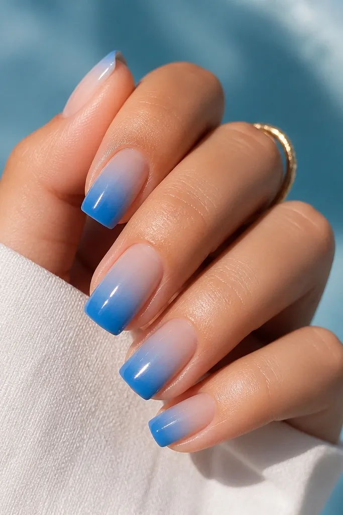 Glossy square nails with a smooth blue gradient from sheer near the cuticle into deeper pool blue at the tips; no harsh line.